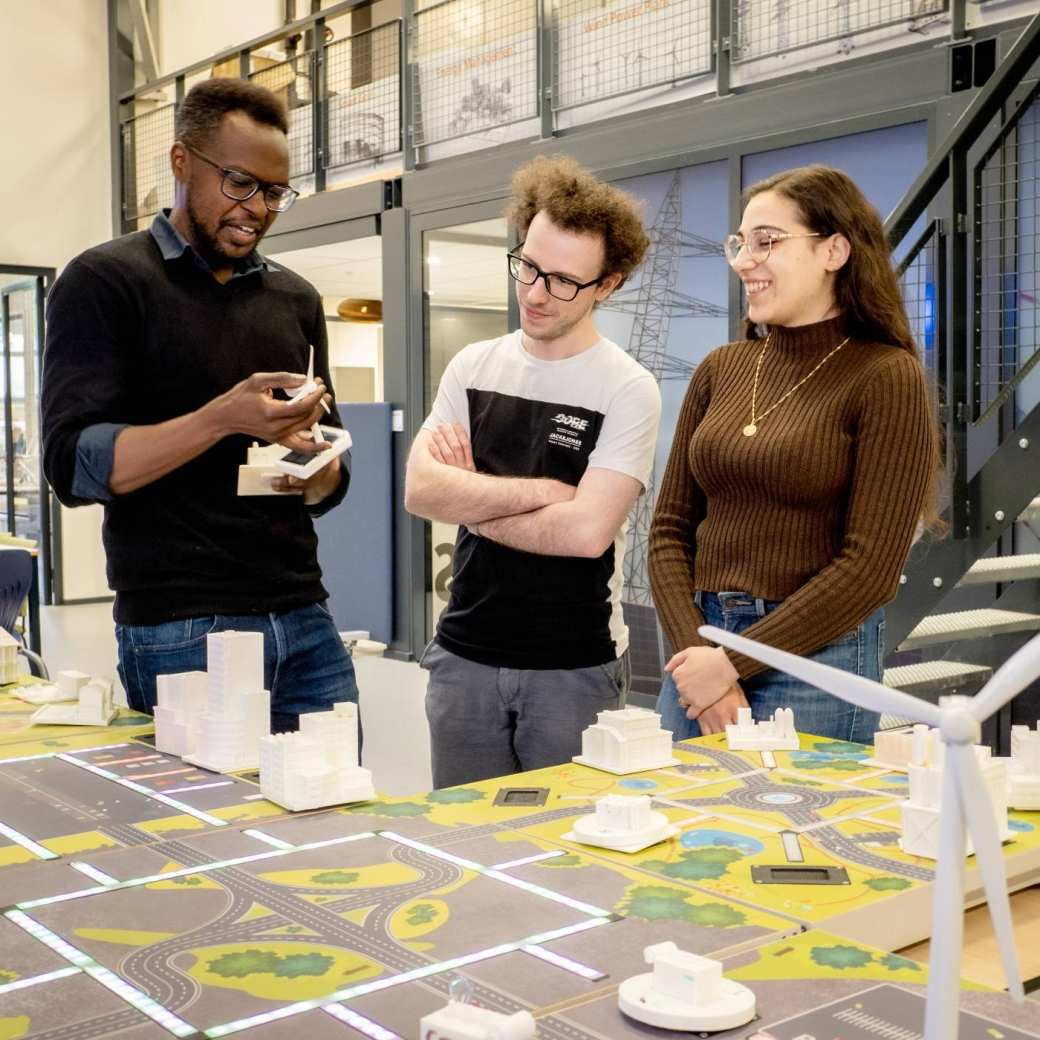 Studenten van de Master Engineering Systems Sustainable Energy en een docent bij de Smart Grid-tafel