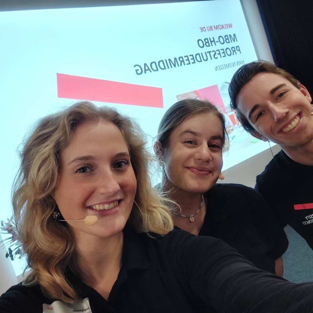 mbo-hbo proefstudeermiddag, 3 studenten lachen voor powerpoint