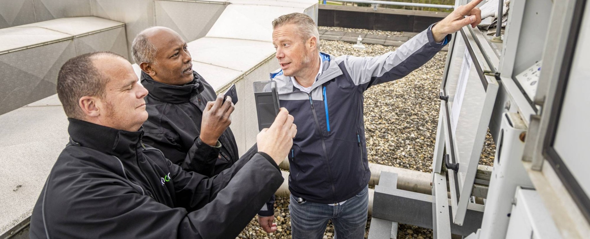 Drie Vastgoedinspecteurs overleggen tijdens een inspectie.