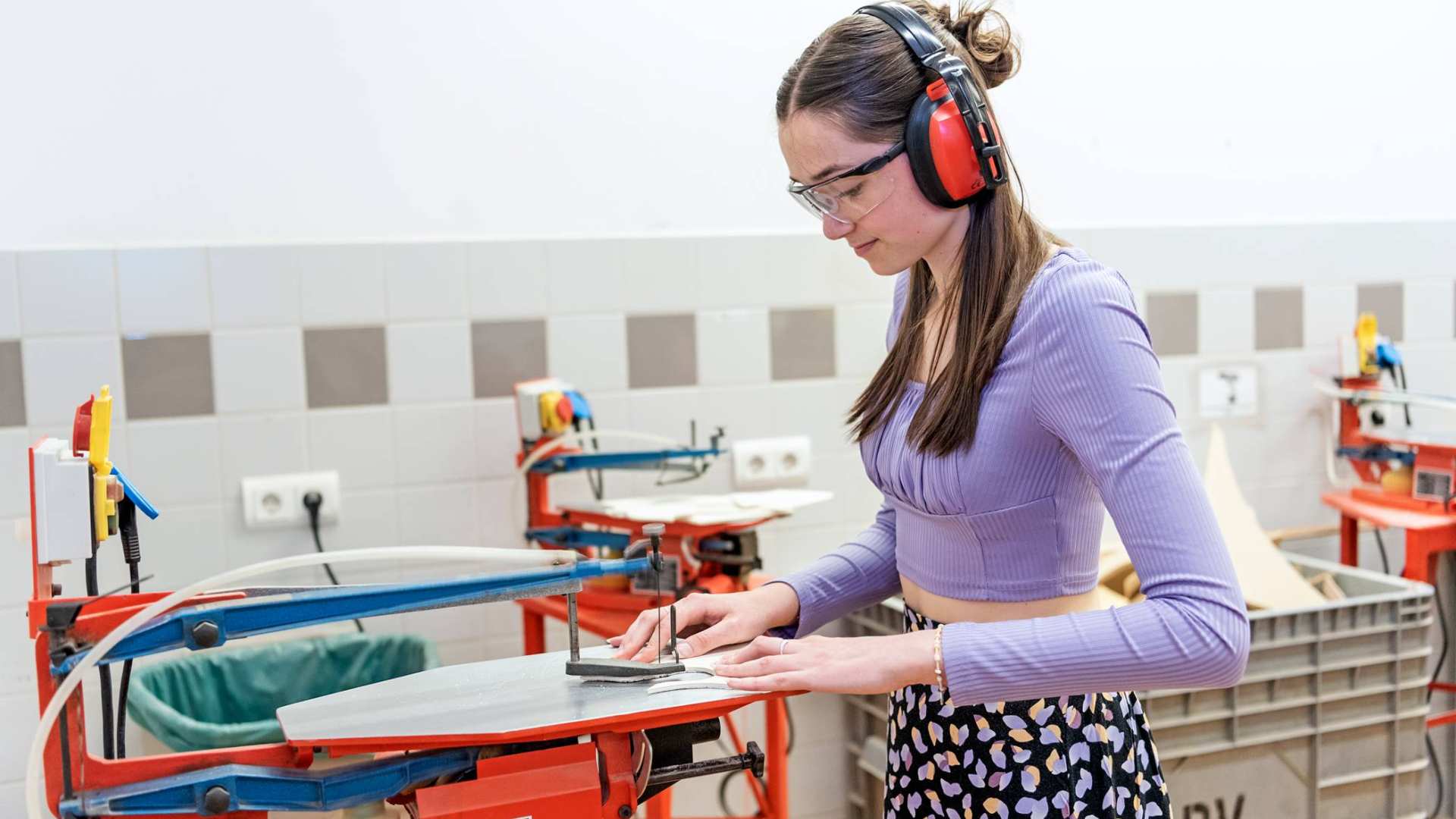 Studente bewerkt hout in houtlokaal