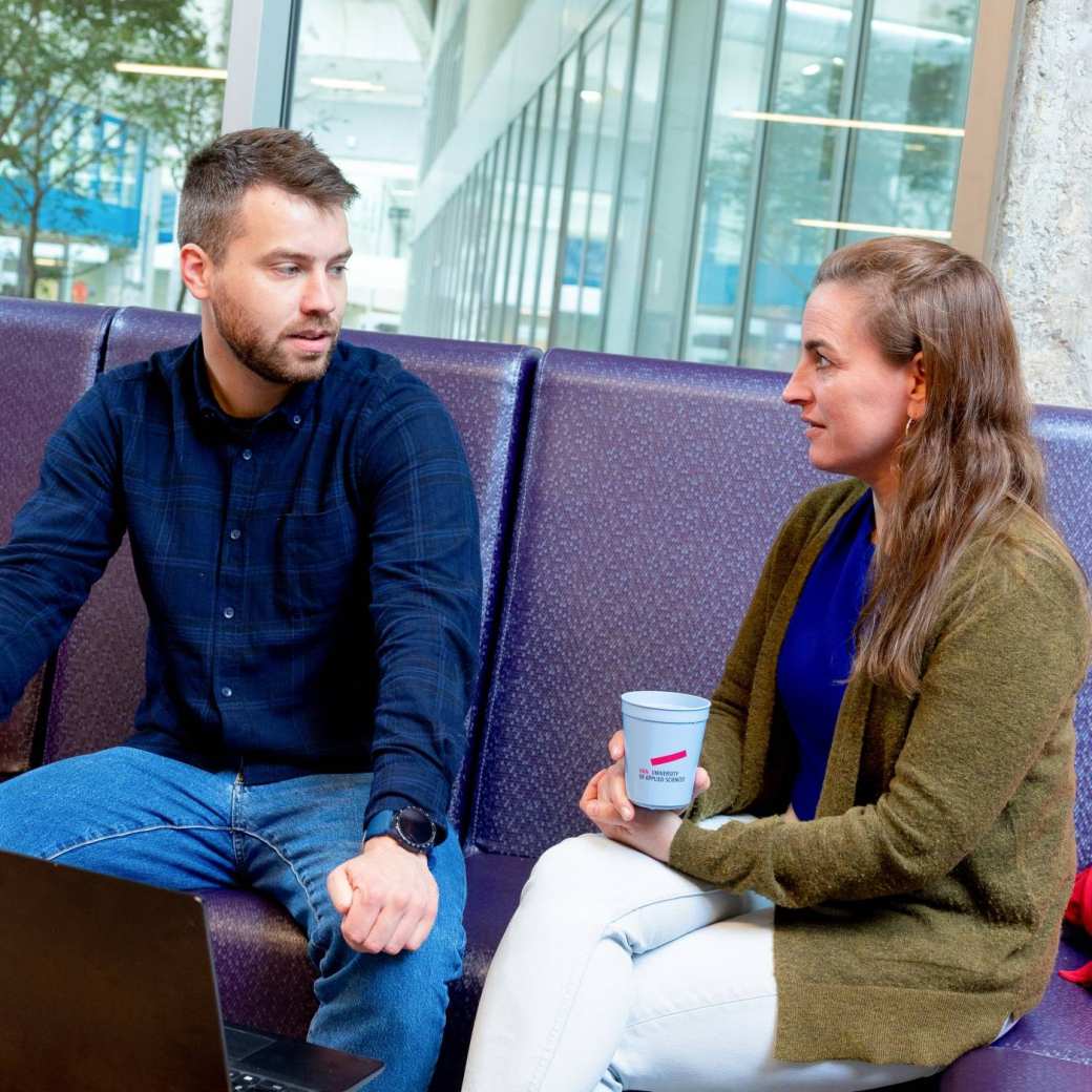 Twee studenten in gesprek met laptop op voorgrond. Master Circulaire Economie (DT) 2024.