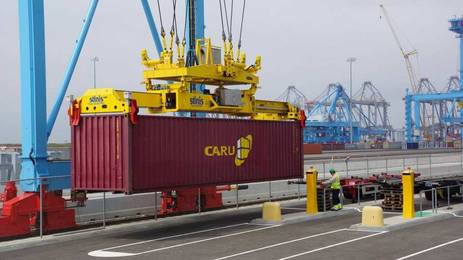 Een container wordt opgetild voor transport.