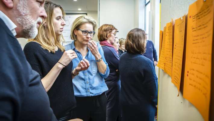 studenten staan kijken naar muur