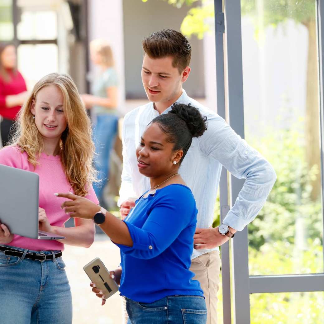 HBO master studenten overleggen via beeldbellen op de laptop in de hal op Han locatie