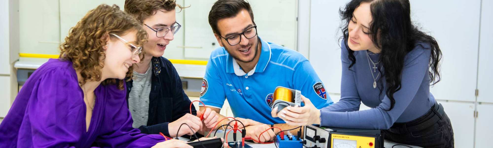 Vier studenten voeren een elektrisch circuit uit.
