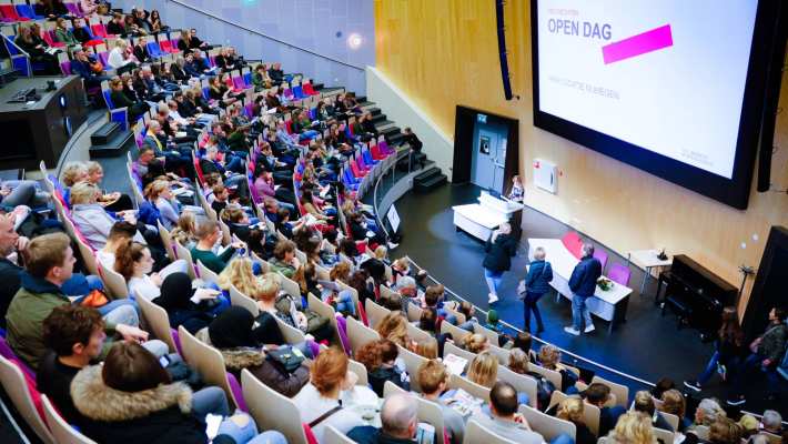 van bovenaf in auditorium met volle zaal voor presentatie