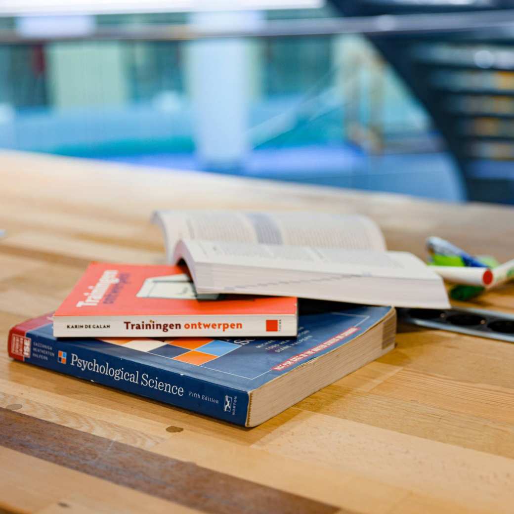 Boeken op tafel. Ter illustratie om meer te lezen over het onderzoek Beter Leren door Beter Slapen.