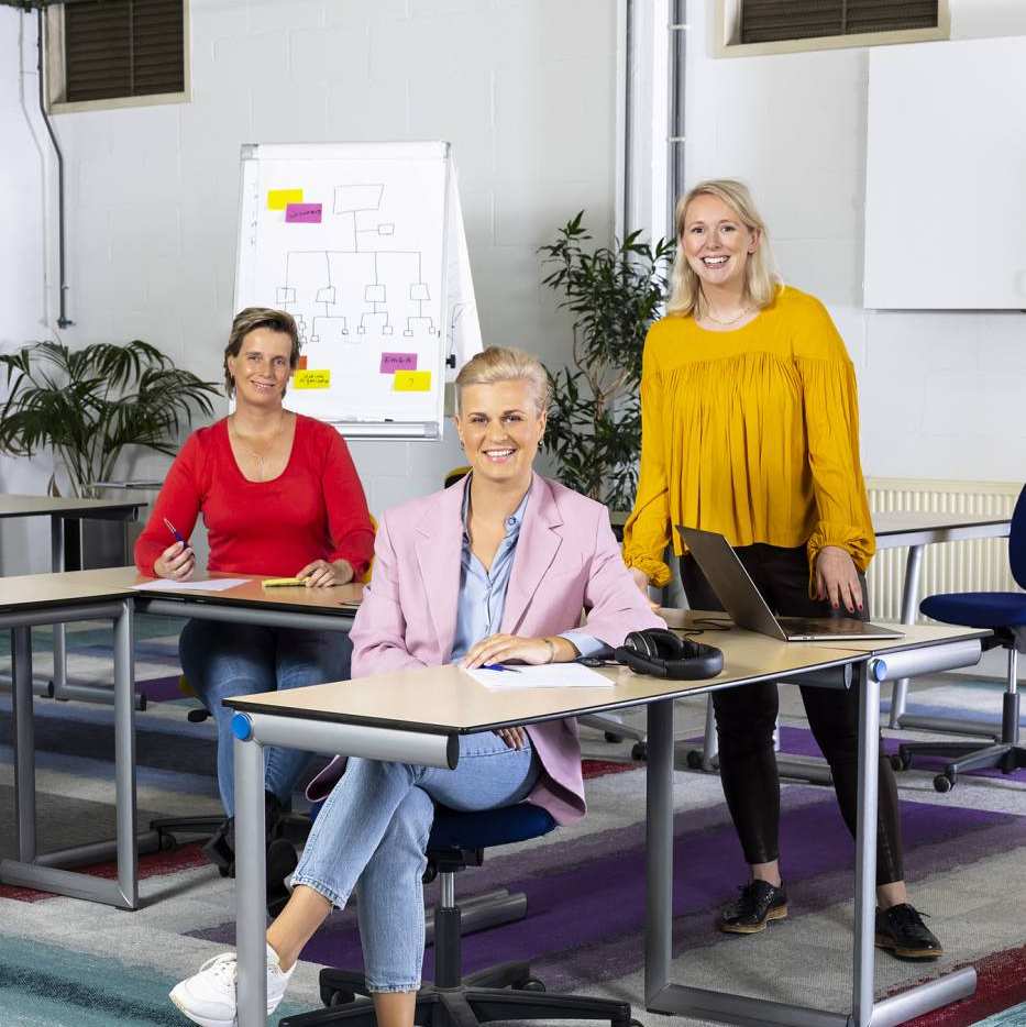 Adviseur achter een tafel op de open avond van de associate degree Logistiek deeltijd