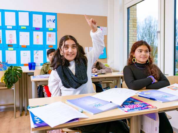 Groep 5,6,7 op de school Da Vince. De leerling steekt haar vinger op in de klas. 