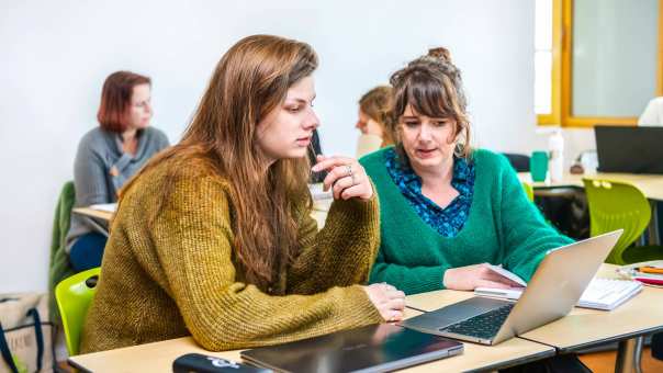 Twee studenten Leraar Engels werken samen op één laptop.
