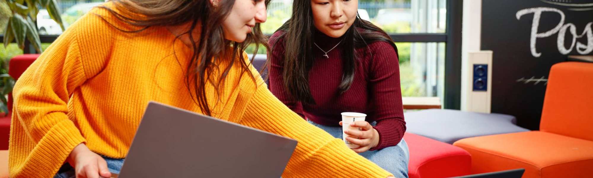 Twee studenten met laptop overleggen en wijst naar scherm