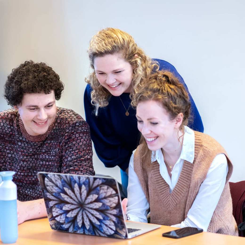 3 studenten van de han master physician assistant kijken lachend op een laptop