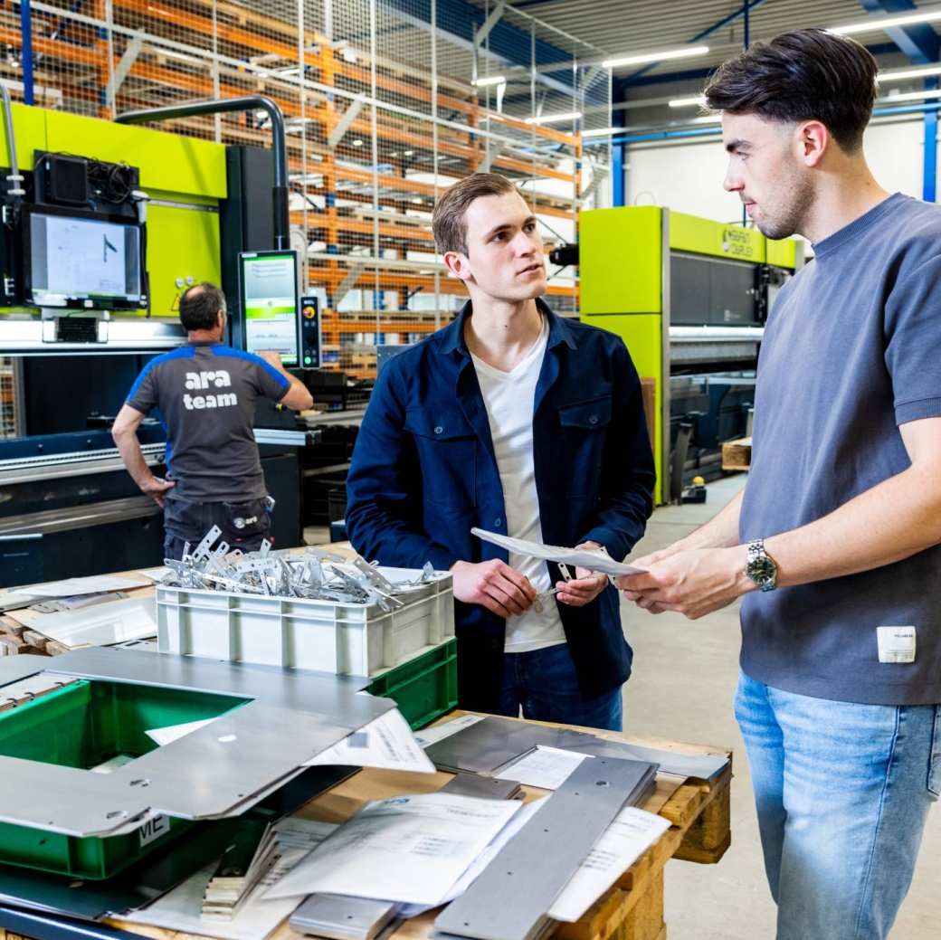 De Technische Bedrijfskunde studenten Derk en Jort overleggen op de werkvloer van ARA.