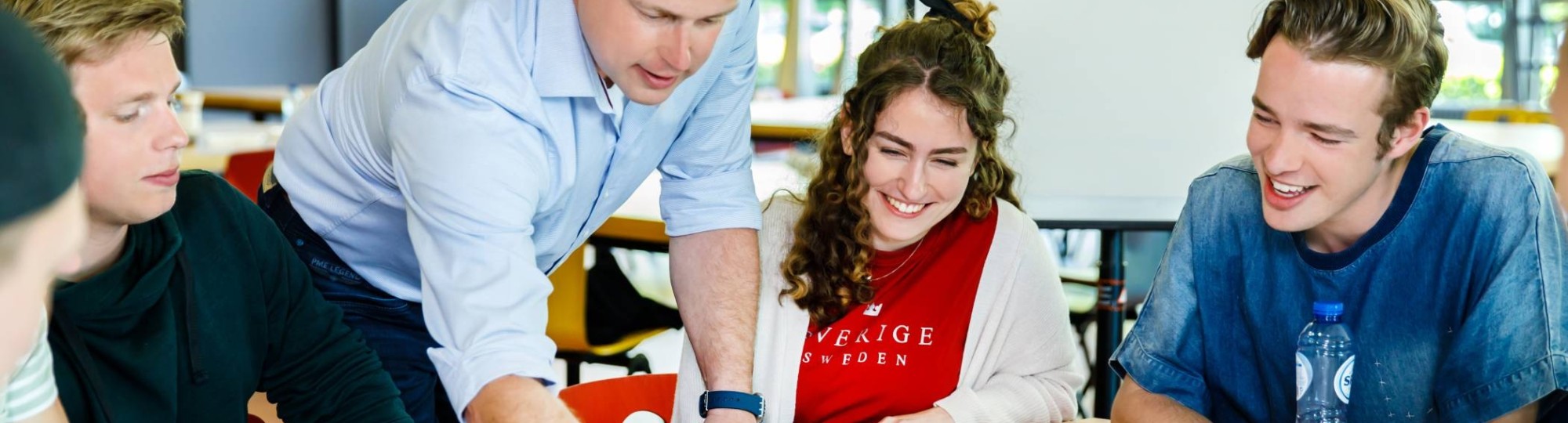 Een docent geeft uitleg aan studenten die een associate degree volgen.