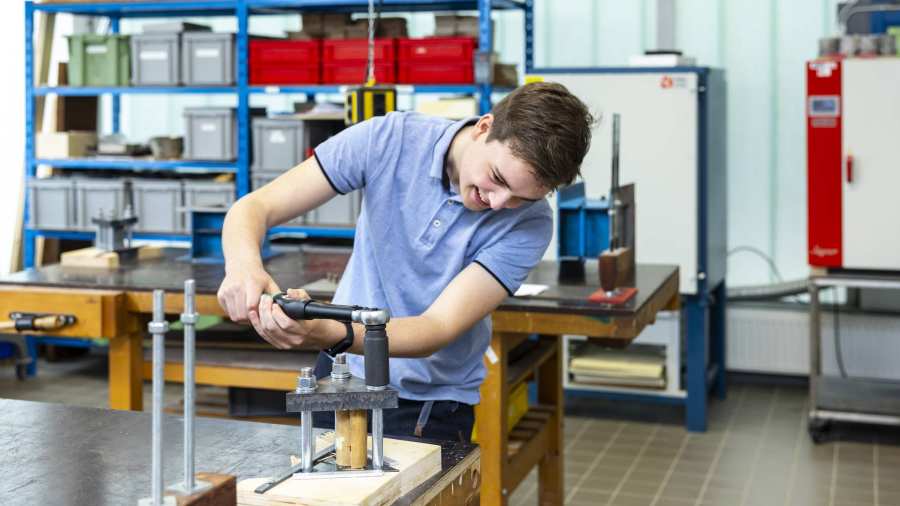 bouwkundestudent bij de werkbank in de werkplaats