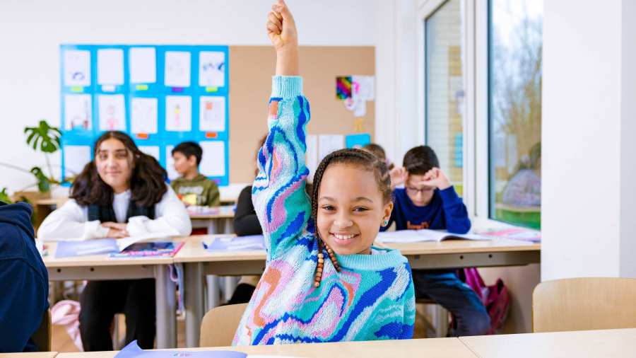 Groep 5,6,7 op de school Da Vince. Een meisje steekt in de klas haar vinger op. 