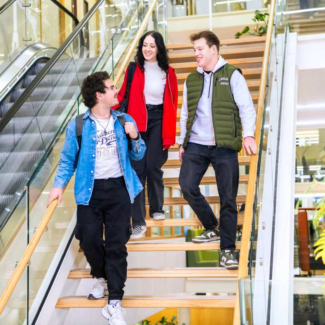 Drie studenten lopen de trap af op de HAN campus in Nijmegen.