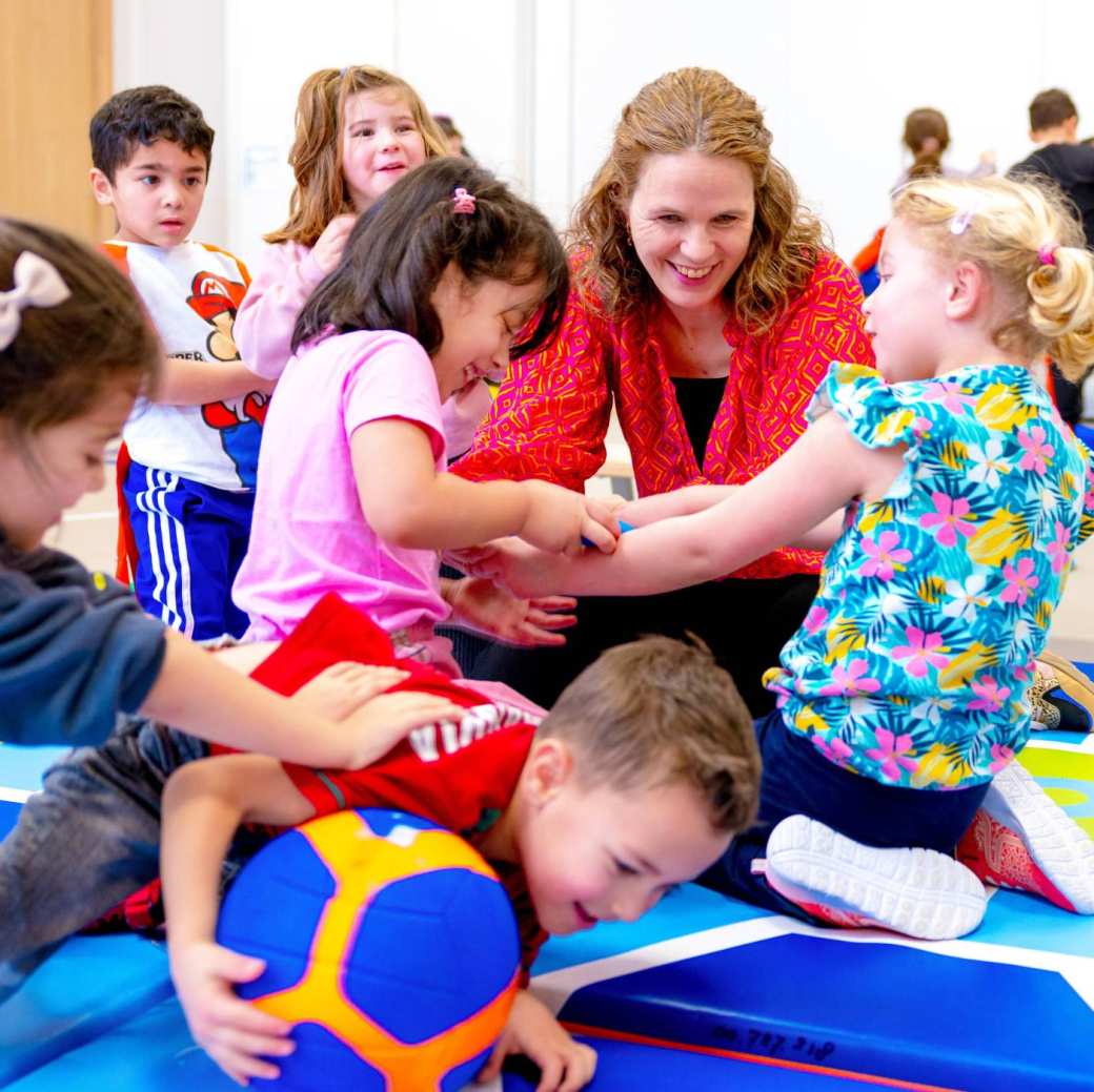 Deeltijdstudent geeft basisschoolkinderen gymles.