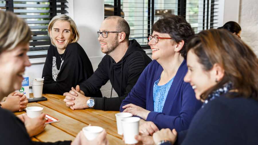 mannen en vrouwen aan tafel pratend