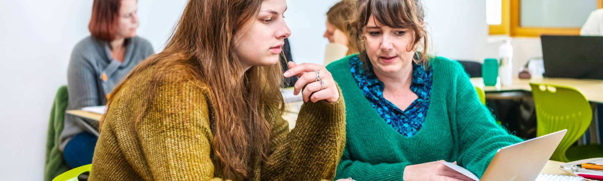 Twee studenten Leraar Engels werken samen op één laptop.
