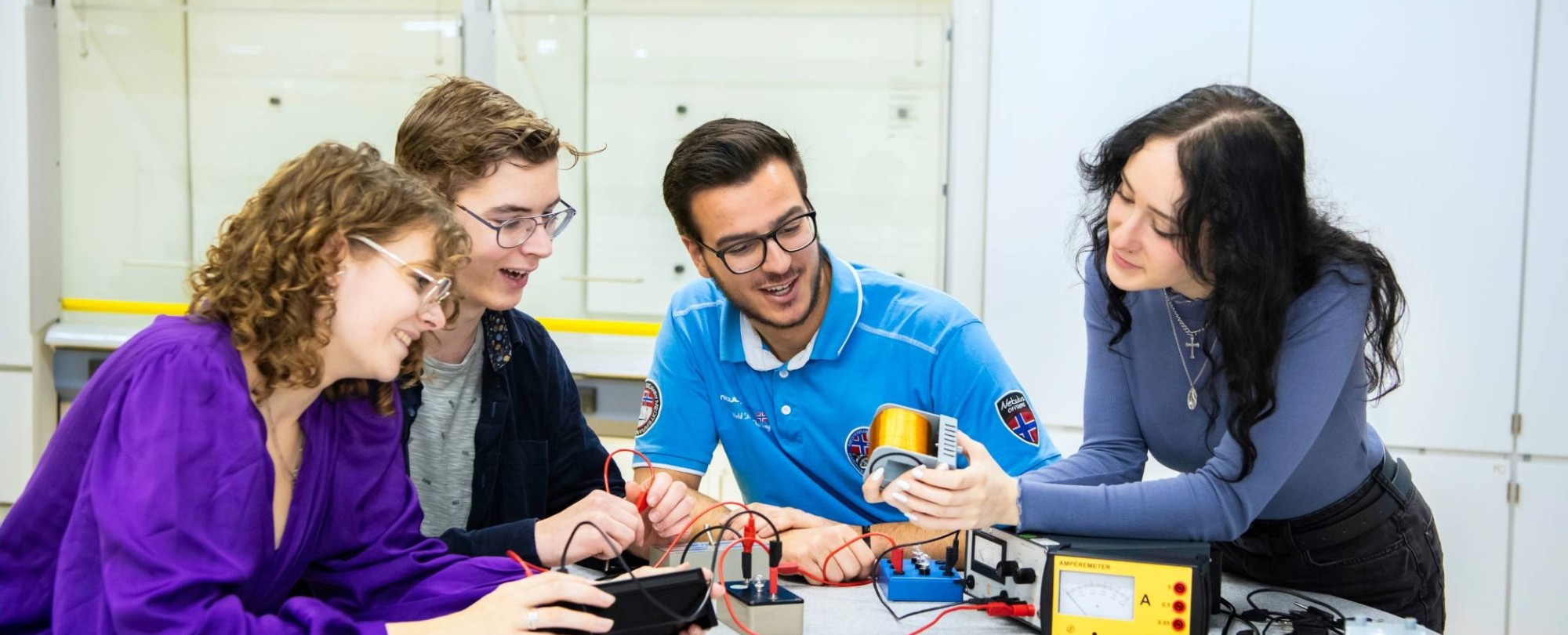 Vier studenten voeren een elektrisch circuit uit.
