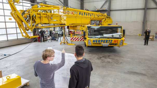 Studenten Constructeur Werktuigbouwkunde op de werkplek met constructietekening. Rechtenvrije foto uit de techniekbeeldbank. Academie Engineering en Automotive.