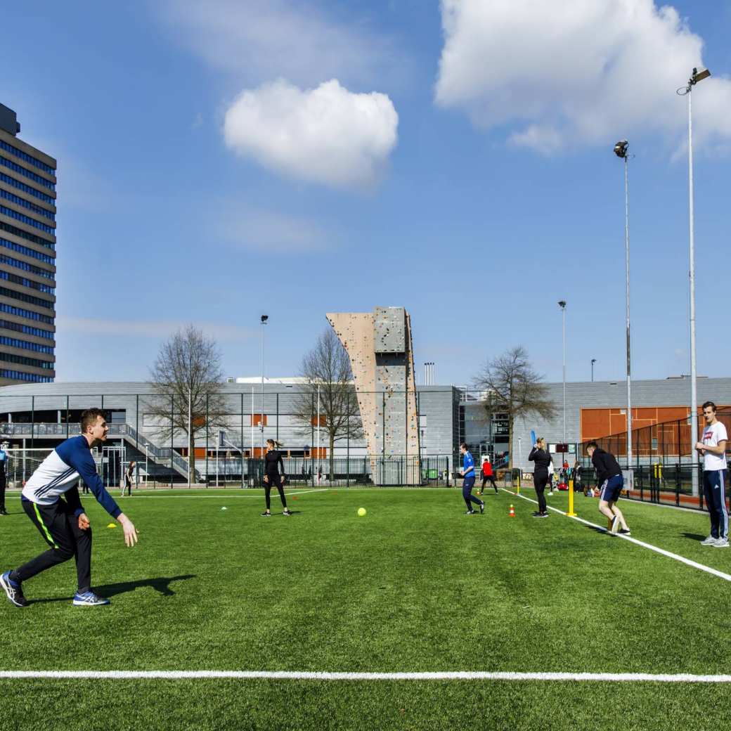 Cricketsporters buiten op het grasveld van het sportterrein van het sportcentrum