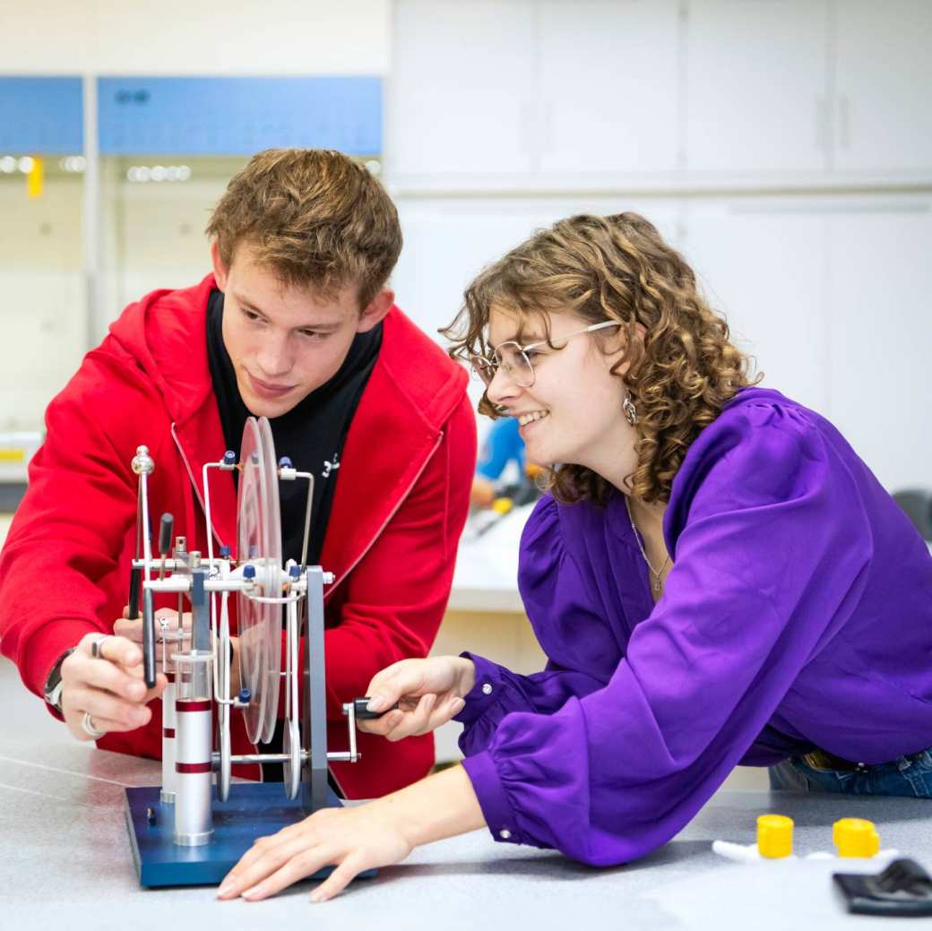 Twee studenten voeren een proef uit.
