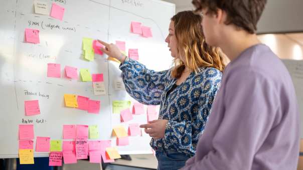 Studenten plakken post-its, projectonderwijs in de klas. 