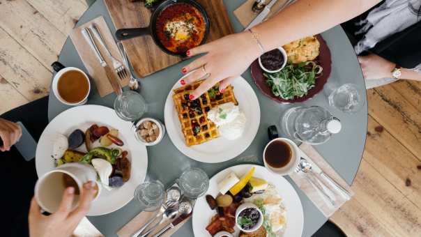 Tafel met eten, hand over de tafel