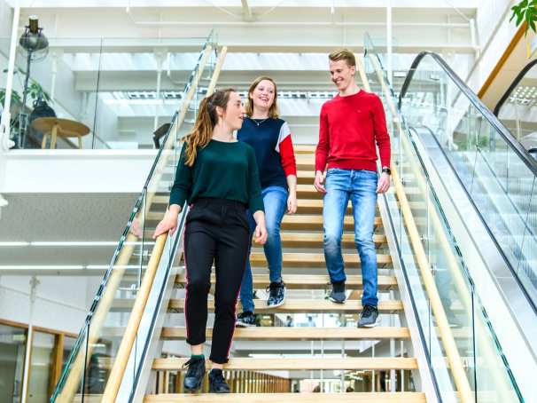 Drie studenten lopen de trap af in het I/O gebouw op de HAN campus in Nijmegen. 