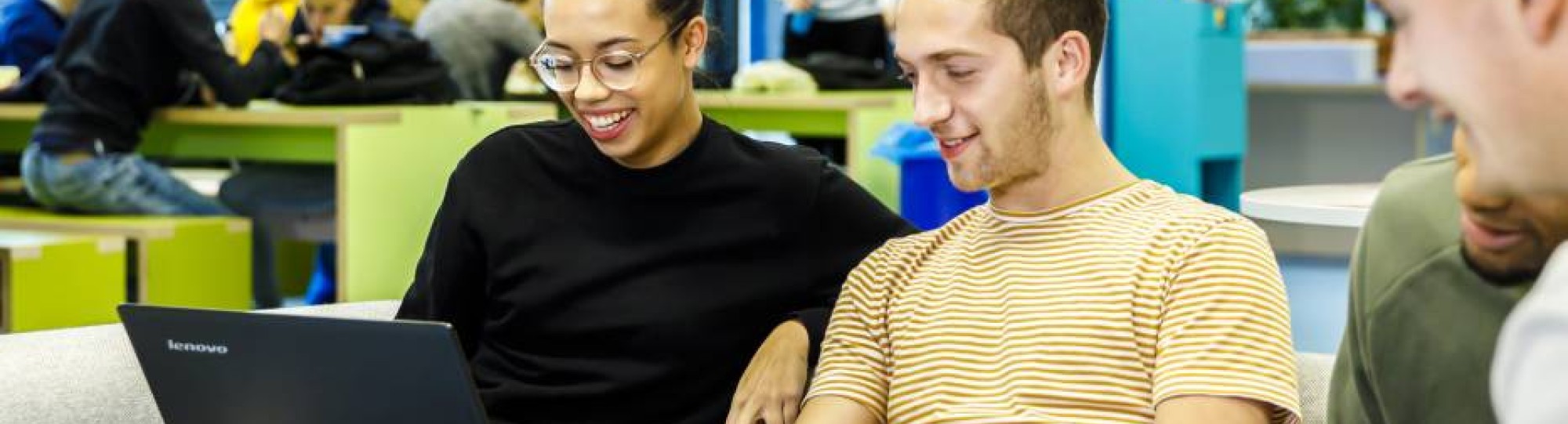 Studenten op bank kijkend naar laptop