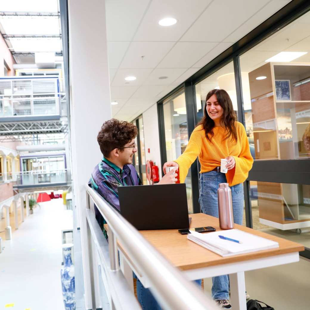 Twee studenten in gesprek met basecamp op achtergrond