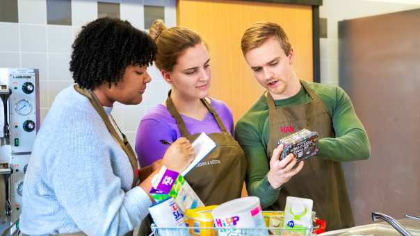 Studenten lezen de verpakking van een pakje boter.