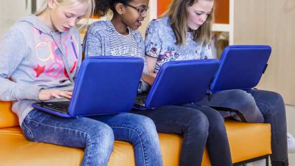 Drie studenten werken op laptop