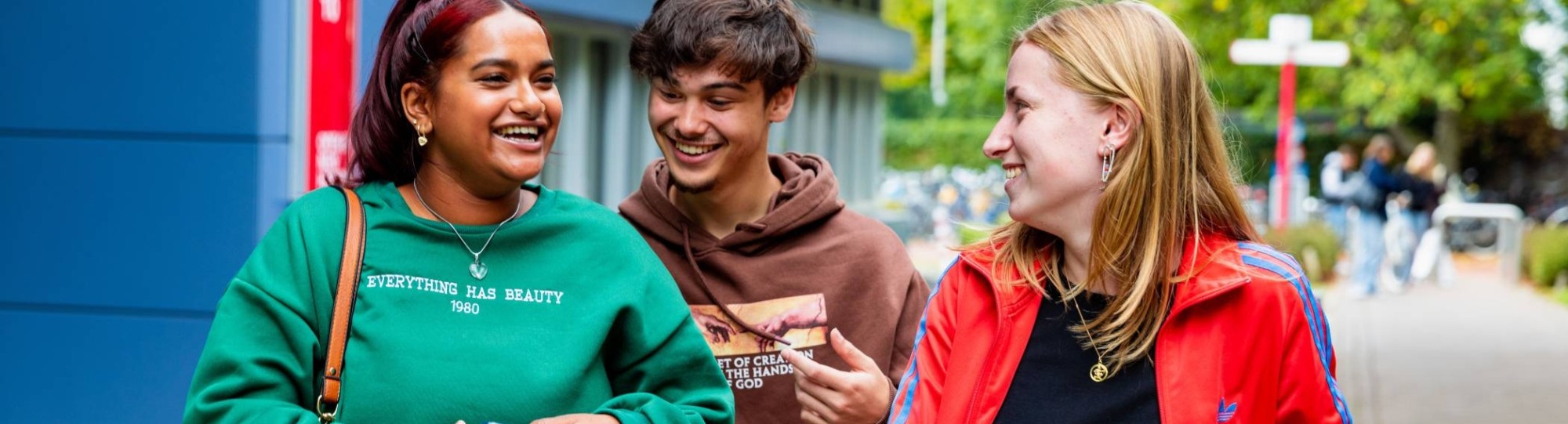 3 studenten lopen buiten op HAN campus