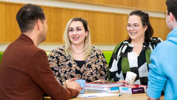 Twee vrouwen lachen tijdens een gesprek. 