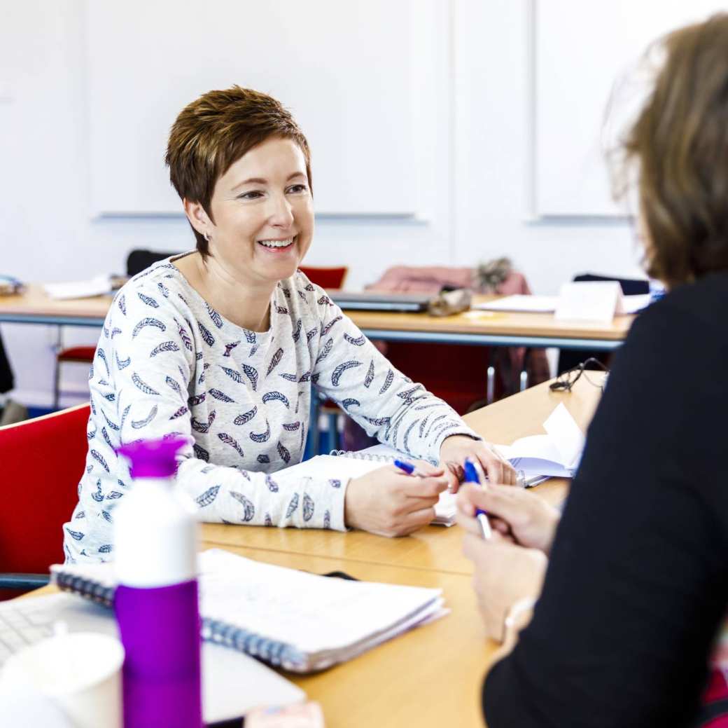 Twee vrouwen overleggen in een klaslokaal