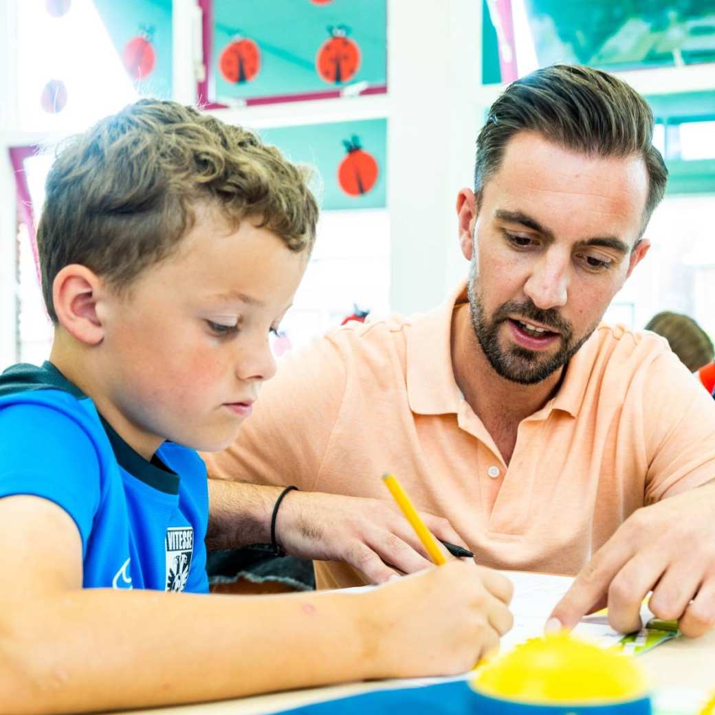 Leerlingen op de basisschool aan een tafel met de juf.