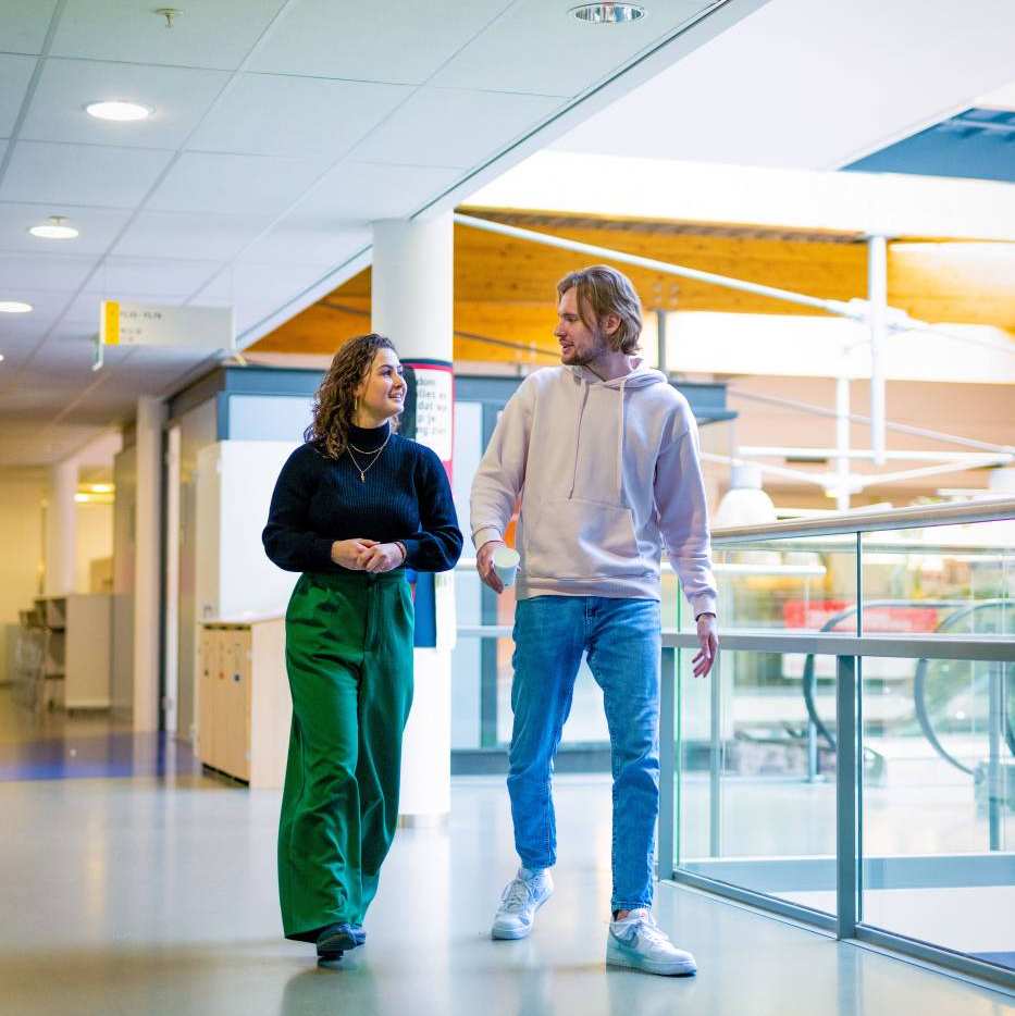 2 HAN studenten Accountancy wandelen door de gang van het schoolgebouw in Nijmegen