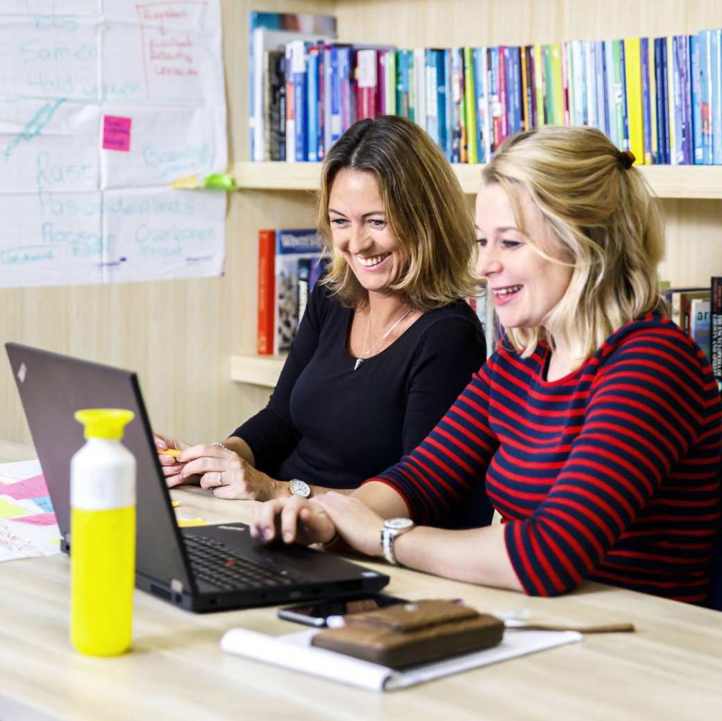 Letty en Marloes werkend bureau lachend