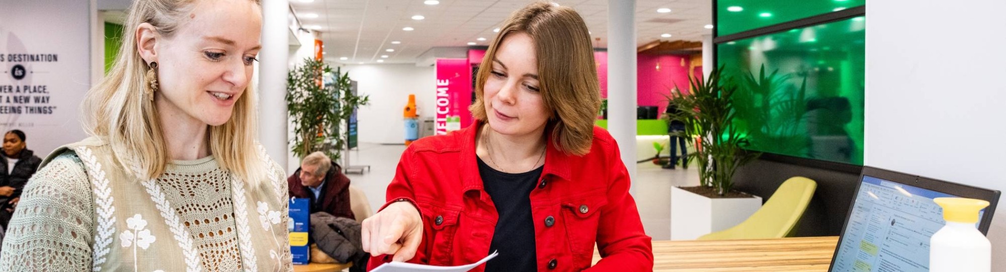 dame met een rood jasje in gesprek met ene dame in een beige trui