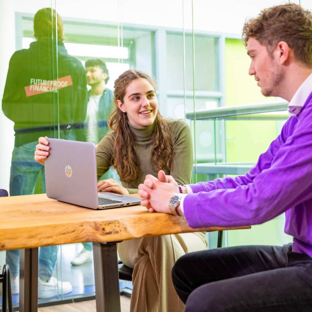 2 HAN Accountancy studenten in overleg achter de laptop in een overlegruimte