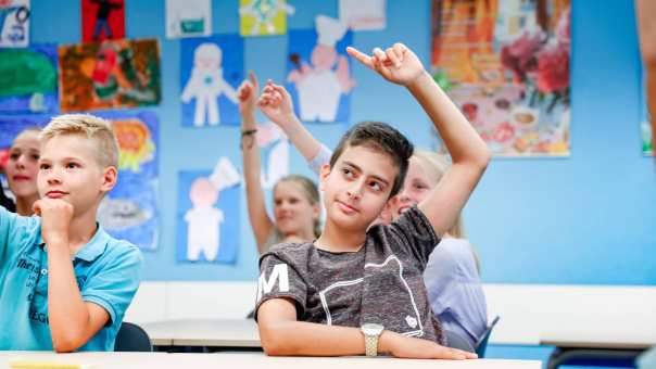 5 kinderen zitten in de klas en steken hun vinger op.