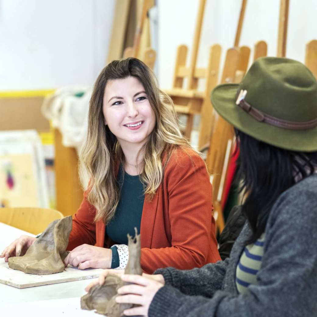 twee masterstudenten beeldende therapie zitten te boetseren