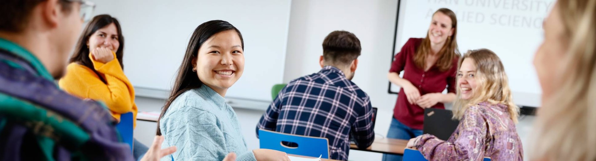 Docent voor een klas lachende studenten