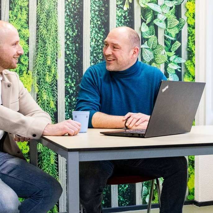 Een studieadviseur en docent heeft een gesprek met een student Bedrijfskunde deeltijd