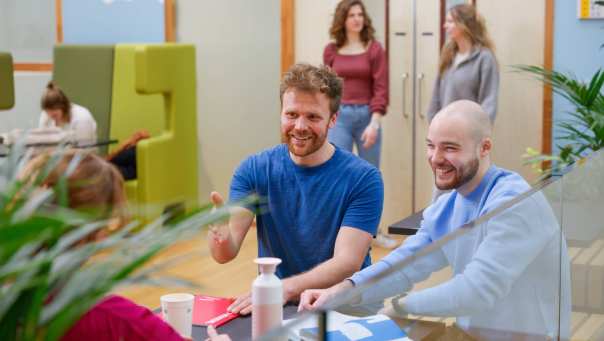 Drie deeltijdstudenten zitten aan een tafeltje en zijn in gesprek