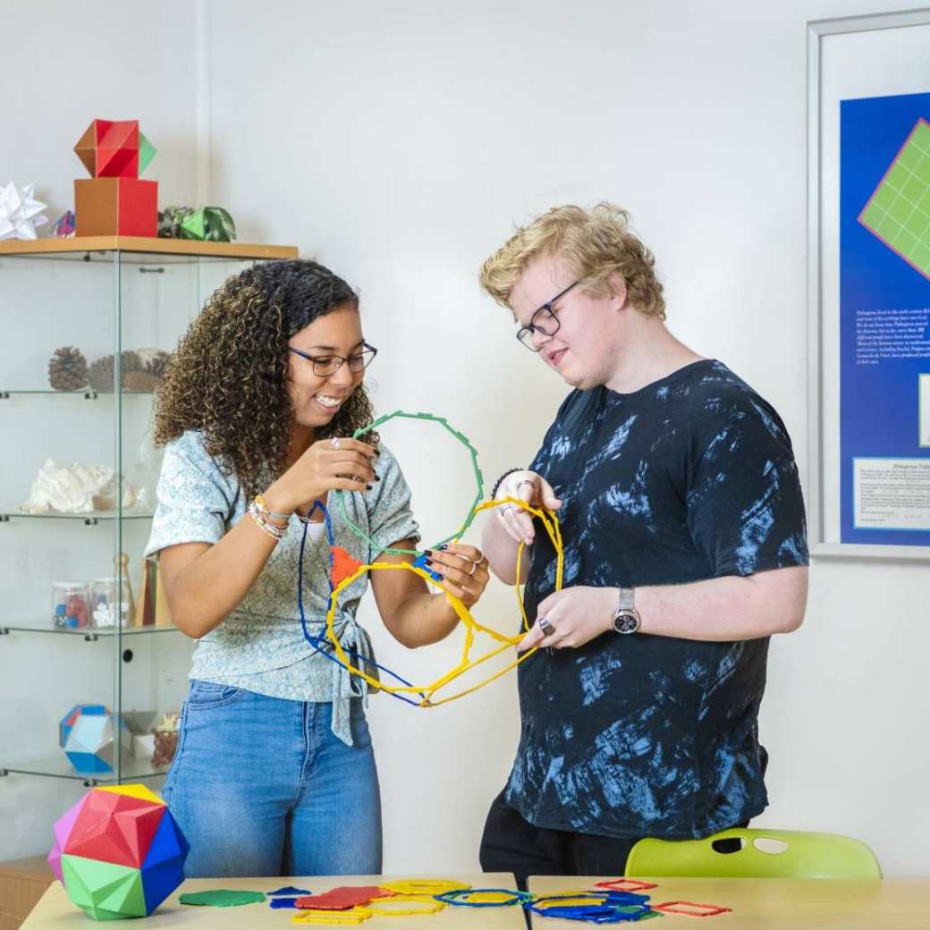 Twee studenten Leraar Wiskunde schuiven grote ringen in elkaar