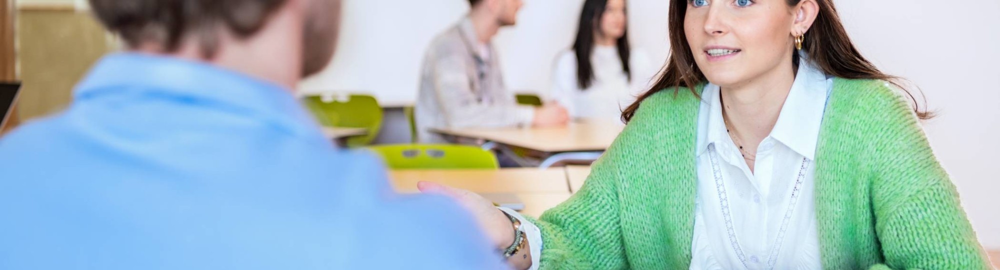 Studenten van Leraar Economie kijkt jongen aan.